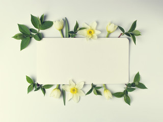 A creative frame of flowers and leaves, with an empty pest for text. Flat lay. Nature concept