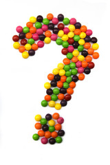  Question mark from multi-colored dragee on a white isolated background.