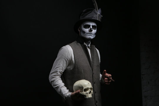 Guy in a makeup with a cigarette and a skull