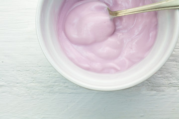 Pink yoghurt with spoon closeup in cup