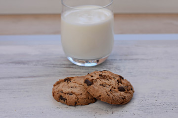 Chocolate chips cookies/ American cookies/ and healthy glass of milk at light wooden background/ Healthy morning