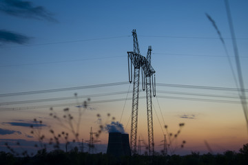 Support and power lines on sunset background.