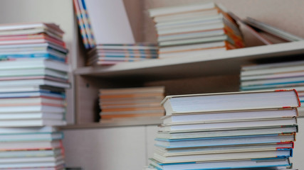 Pile of books on the floor and on the closet.