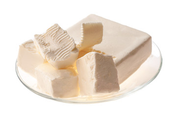 Butter pieces in bowl isolated on white background, close-up