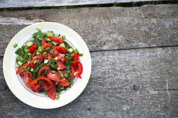 Full bowl of fresh vegetable salad on a wooden table. Copy space. Top view. Flat lay. From above.