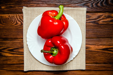 Two red peppers lying on a linen tablecloth 