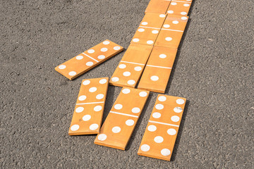 Large wooden dominoes on the asphalt on a summer day