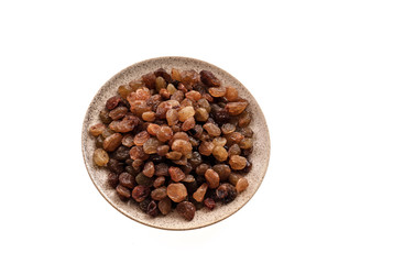 Raisins in saucer on white, closeup