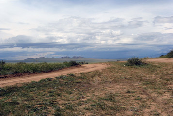 Wide steppe with yellow grass under a blue sky with white clouds Sayan mountains Siberia Russia