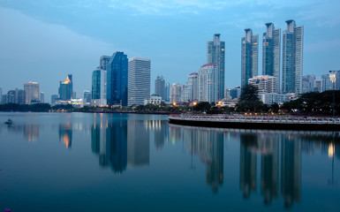 Beautiful Benchakitti Park near the skyscraper business district,View Bangkok city with park at twilght with reflection of skyline,Thailand