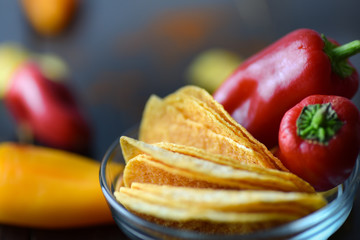 Potato chips with paprika on dark wooden background