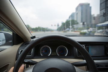 Driving car on city street wating infront of the traffic light