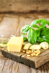 Ingredients for pesto sauce. Cheese, garlic, basil, pine nuts, olive oil.