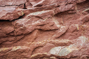 Background of natural sandstone, banded, red or brown, colored texture background. Stone surface texture closeup