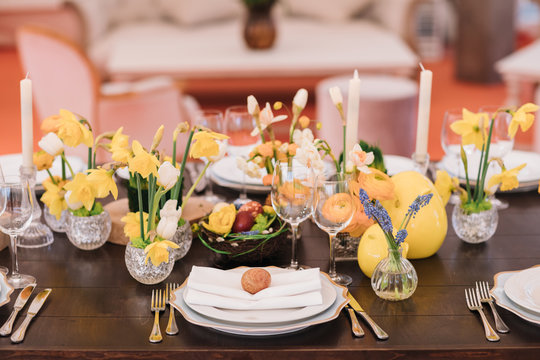 Easter table set in yellow green colors and eggs in the middle