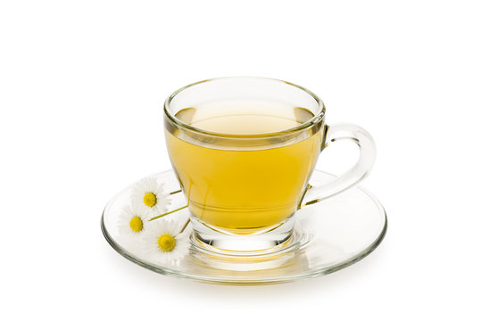 chamomile in glass cup with daisy on white background