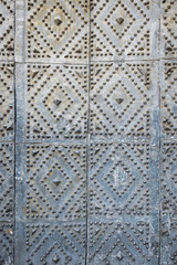Abstract detail of medieval metal doors with studs in diamond pattern