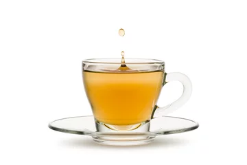 Crédence de cuisine en verre imprimé Theé thé dans une tasse en verre avec des éclaboussures de gouttes, sur fond blanc.
