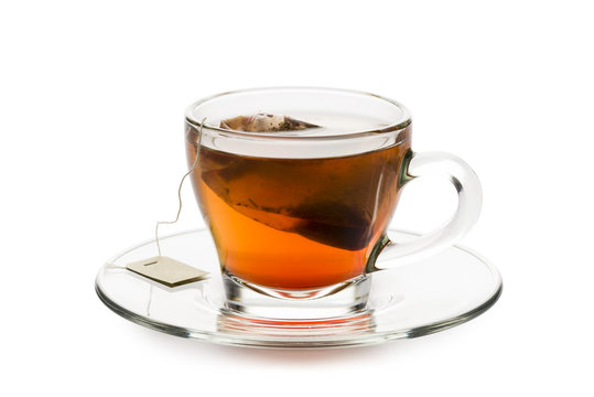 tea in glass cup with tea bag inside, on white background