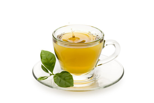 tea in glass cup with leaves and drop splashing, on white background