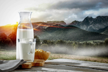 Fresh milk and landscape of mountains with fog and sunrise. Free space for your milk product. 