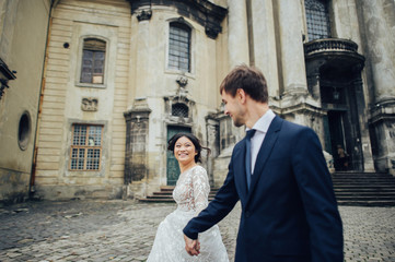 newly wedded couple posing near antique green door