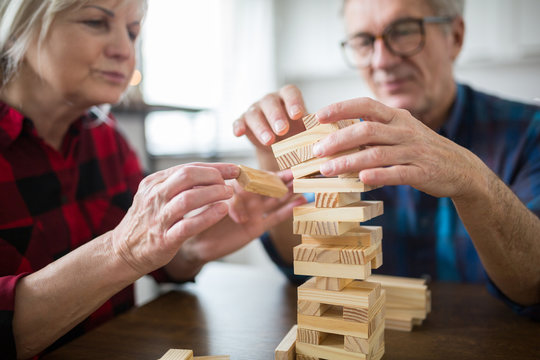 Senior Couple Sitting At Table Playing Jenga