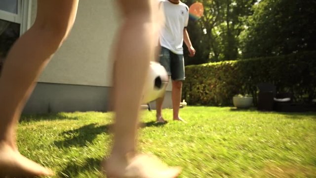 Junge und Mädchen Spielen Fußball im Garten 