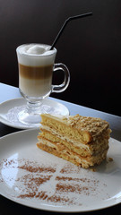 Piece of sweet napoleon cake served with cappuccino detailed photo