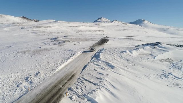 Car driving off, in a rural icy landscape