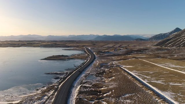 Car driving along winding road in South East Iceland. Beautiful scenery on the horizon.
