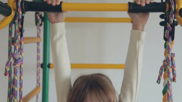 Little girl on wall bars