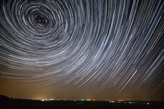 Star trails in the night sky. A view of the starry space and the light above the skyline.