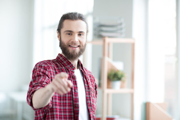 Obraz premium Portrait of casual young businessman pointing at you and smiling
