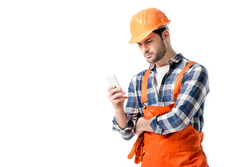 workman in orange overall and hard hat using smartphone isolated on white