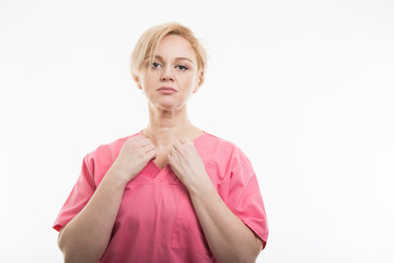 Pretty female nurse wearing pink scrubs arranging shirt