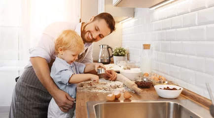 Crédence de cuisine en verre imprimé Cuisinier famille heureuse dans la cuisine. père et enfant préparant des biscuits