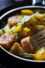 Fried potatoes with sausages close up