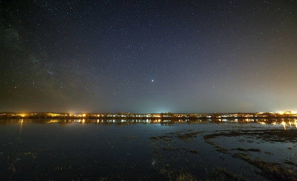 Night sky with stars above the river during the spring flood. View of the starry space.
