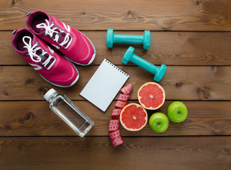  sneakers dumbbells bottle of water apple and measure tape