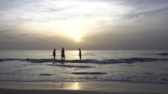 sunset on the beach in Israel. Children in the backlight dance in the water