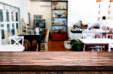 Selected focus empty brown wooden table and Coffee shop or restaurant blur background with bokeh image. for your photomontage or product display.
