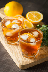 Glasses of cold ice tea with lemon, ice, mint on background. Homemade lemonade. Spring and summer drinks and beverages concept. 