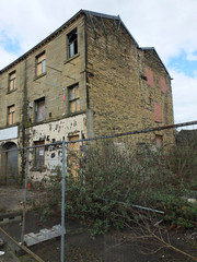 derelict abandoned industrial mill in huddersfield england with boarded up and broken windows