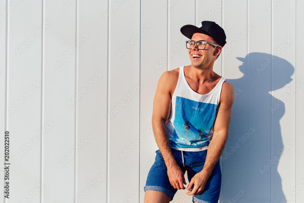 Wall mural Smiling guy in stylish clothes posing outdoors.