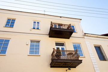 Old balconies, attics on a two-story apartment building with windows. Retro photo