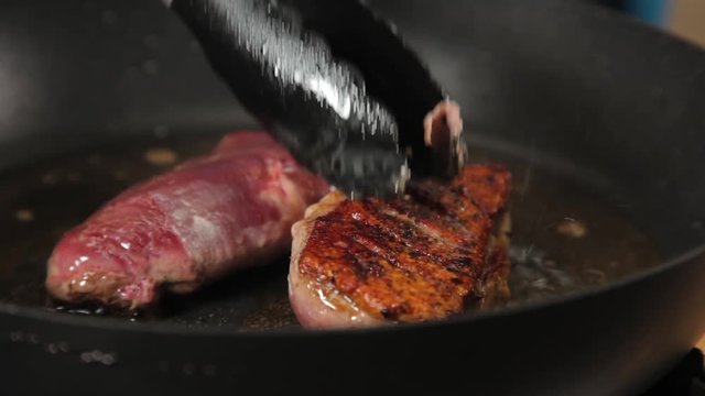 A close up shot hof duck breast meat being seared on a hot pan.