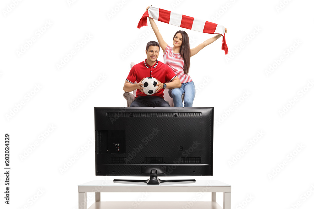 Sticker cheerful soccer fans seated in an armchair watching a game of football on tv