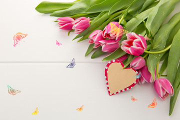 Mother's Day card and a bouquet of beautiful tulips on wooden background.