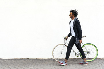 Handsome young man using mobile phone and fixed gear bicycle.